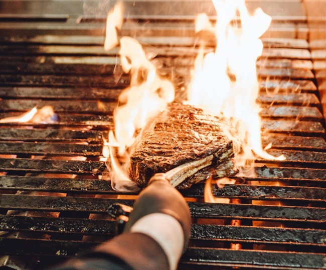 von Flammen "geküsstes" Tomahawk am Grill